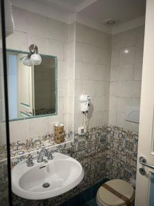 a bathroom with a sink and a toilet at Hotel America in Marina di Camerota