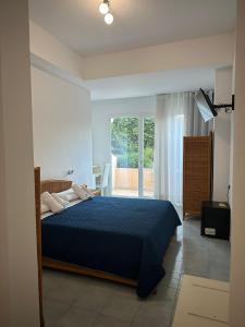a bedroom with a blue bed and a balcony at Hotel America in Marina di Camerota