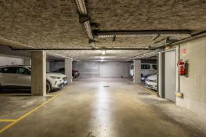 un parking avec deux voitures garées à l'intérieur dans l'établissement Studio Charpennes - Parking privé gratuit, à Villeurbanne 1 autre photo