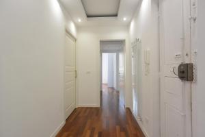 a hallway with white walls and a hard wood floor at Felix House in Savona