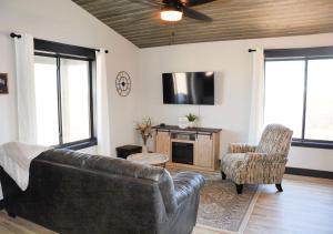 a living room with a leather couch and a tv at Hot Tub & Panoramic Views Bear Butte &Buffalo Chip in Sturgis