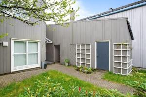une maison grise avec une porte et des fenêtres bleues dans l'établissement Forus - ONS, à Stavanger