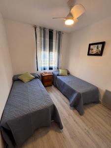 a bedroom with two beds and a ceiling fan at Luxury Family Levante Beach in Benidorm