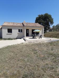 a small house with a table and an umbrella at villa soleil in Ruoms