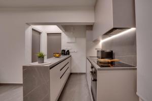 a kitchen with white cabinets and a counter top at Sea Front Luxury Apartment in Oroklini