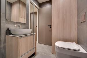 a bathroom with a white toilet and a sink at Sea Front Luxury Apartment in Larnaka