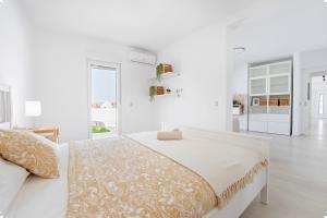 una camera bianca con un grande letto e pareti bianche di Villa Alex Costa Adeje ad Adeje Altre 58 foto