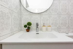 a white bathroom with a sink and a mirror at Himara City 33 - Central, Beach Access in Himare