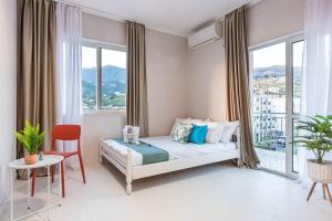 a bedroom with a bed and a large window at Himara City 33 - Central, Beach Access in Himare