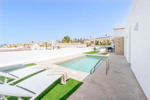 una piscina con sedie a sdraio e una piscina di Villa Alex Costa Adeje ad Adeje
