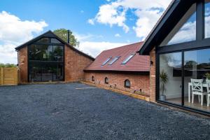 an external view of a brick house with large windows at The Oak Barn in Southampton