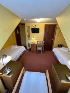 a hotel room with two beds and a desk at Butlers Guest House in Aberdeen