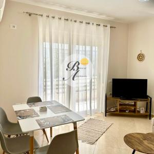 a living room with a table and a television at Breeze Home in Vlorë