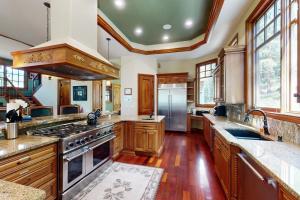 eine große Küche mit Holzschränken und Geräten aus Edelstahl in der Unterkunft Moose Whiskers in Keystone