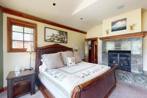 ein Schlafzimmer mit einem Bett und einem Kamin in der Unterkunft Moose Whiskers in Keystone