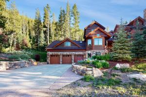 ein Blockhaus mit einer Garage und einer Auffahrt in der Unterkunft Moose Whiskers in Keystone