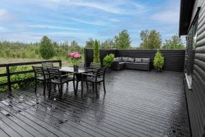 MiðdalurModern Summerhouse Views Outdoor Spaces Patio的一个带桌椅和沙发的甲板