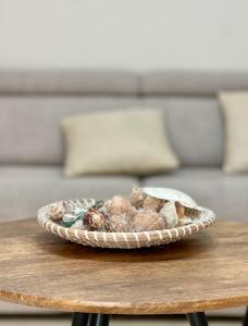 a bowl of shells on a table with a couch at Breeze Home in Vlorë