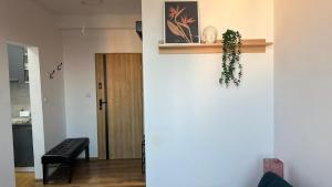 a living room with a plant on the wall at ApartmentsByMatyrafa-IX in Tarnowskie Góry