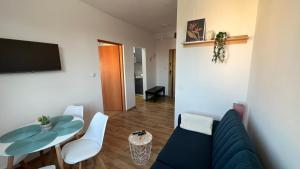 a living room with a blue couch and a table at ApartmentsByMatyrafa-IX in Tarnowskie Góry