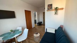 a living room with a blue couch and a table at ApartmentsByMatyrafa-IX in Tarnowskie Góry