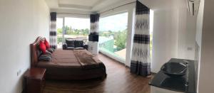 a bedroom with a bed and a couch and a window at Amaze Residence Panoramic Room 3 in Boralesgamuwa