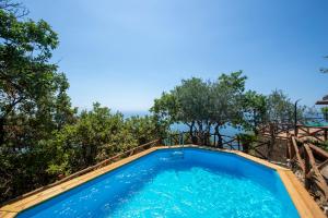 a swimming pool with trees in the background at Casa Allegra in Praiano