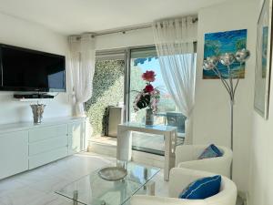 a white living room with a tv and a glass table at CANNES CROISETTE Sea & Sky in Cannes