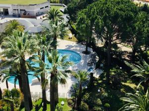 an aerial view of a resort pool with palm trees at CANNES CROISETTE Sea & Sky in Cannes