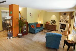 a living room with a blue couch and a fireplace at Hotel Rural Milaleku in Ecala