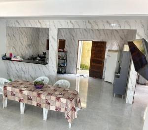 a living room with a table and a kitchen at Casa Praia BRISAMAR in Maragogi