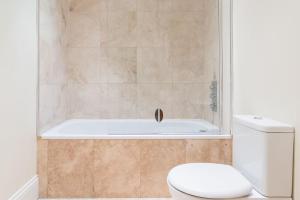 a bathroom with a toilet and a bath tub at Super Central - Georgian Double Upper Flat with Castle Views in New Town in Edinburgh
