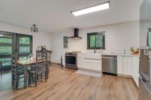 a kitchen with white cabinets and a table in it at 18 Mi to Grand Caverns Cabin with Balcony! in McGaheysville