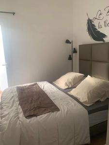 ein Schlafzimmer mit einem großen Bett mit weißer Bettwäsche in der Unterkunft saint cyprien in Saint-Cyprien