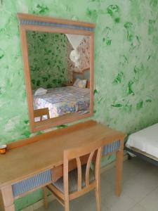 a bedroom with a mirror on a green wall at Hôtel Retba Lodge in Ouayembame