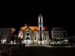 an old church with a tower at night at ApartmentsByMatyrafa-IX in Tarnowskie Góry