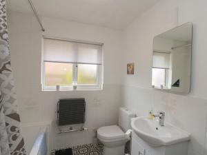a bathroom with a toilet and a sink and a mirror at Castelian in Bridlington +15 photos