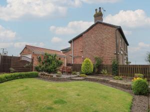 an old brick building with a garden in front of it at Castelian in Bridlington