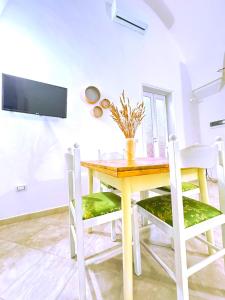 a dining room with a wooden table and chairs at Casa Vacanze Patrizia in Botrugno