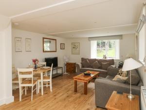 ein Wohnzimmer mit Sofa und Tisch in der Unterkunft Ixworth Cottage in Ottery Saint Mary