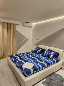 达喀尔Appartement F4 Cité Keur Gorgui,Dakar,Sénégal的一张带蓝色和白色枕头的床