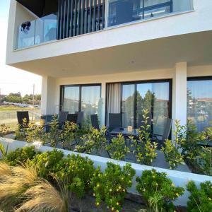 a house with a balcony with chairs and plants at Flâneur in Kallithea Halkidikis