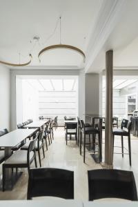 a dining room with tables and chairs and a chandelier at Hotel Corona -Rodier- in Paris
