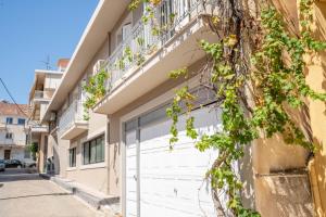 a building with white garage doors and a balcony at La Calma in Argostoli