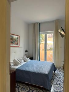a bedroom with a bed and a door to a patio at Hotel America in Marina di Camerota