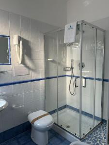 a bathroom with a shower and a toilet and a sink at Hotel America in Marina di Camerota