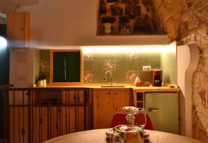 a kitchen with a table and a sink and a refrigerator at Casa Philos in Ceglie Messapica