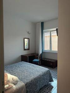 a hotel room with a bed and a window at Hotel America in Marina di Camerota