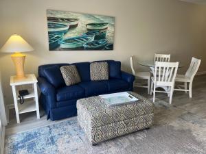 a living room with a blue couch and a table at Summer Sands - 205 by Sea Scape Properties in Wrightsville Beach +34 photos