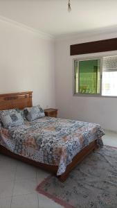 a bedroom with a bed and a window at Appart Tanger Family in Tangier